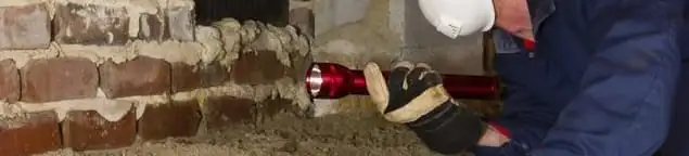Pest control technician inspecting a crawl space for ant activity and entry points in Fort Lauderdale, FL