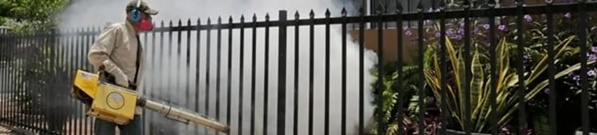 Mosquito control technician fogging a yard perimeter for mosquito reduction in Fort Lauderdale, FL